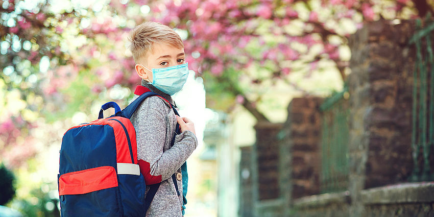 boy with backpack and mask