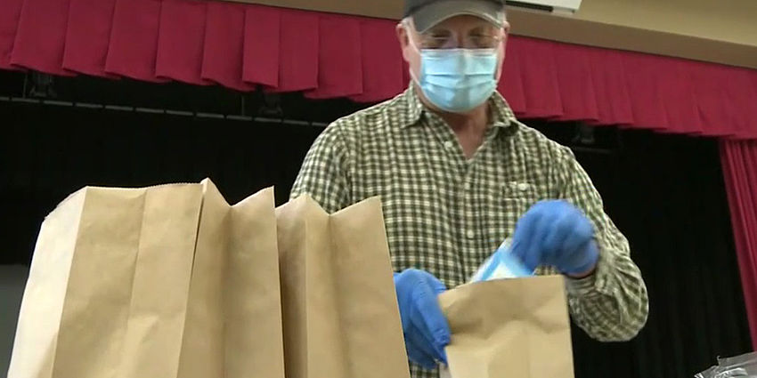 worker preparing to-go meals at school