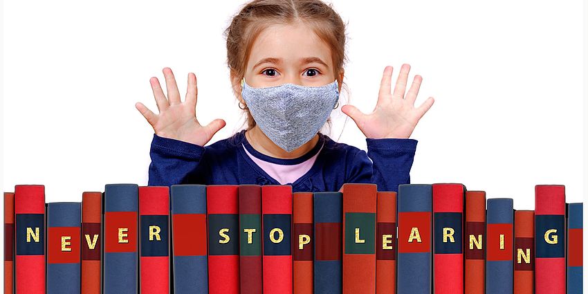 young girl in mask with books