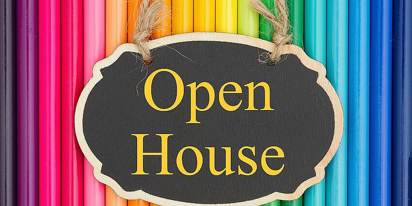 colored pencils with sign for open house