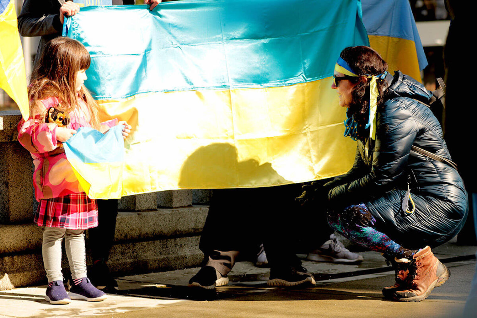 young girl and a woman stand with flag of Ukraine