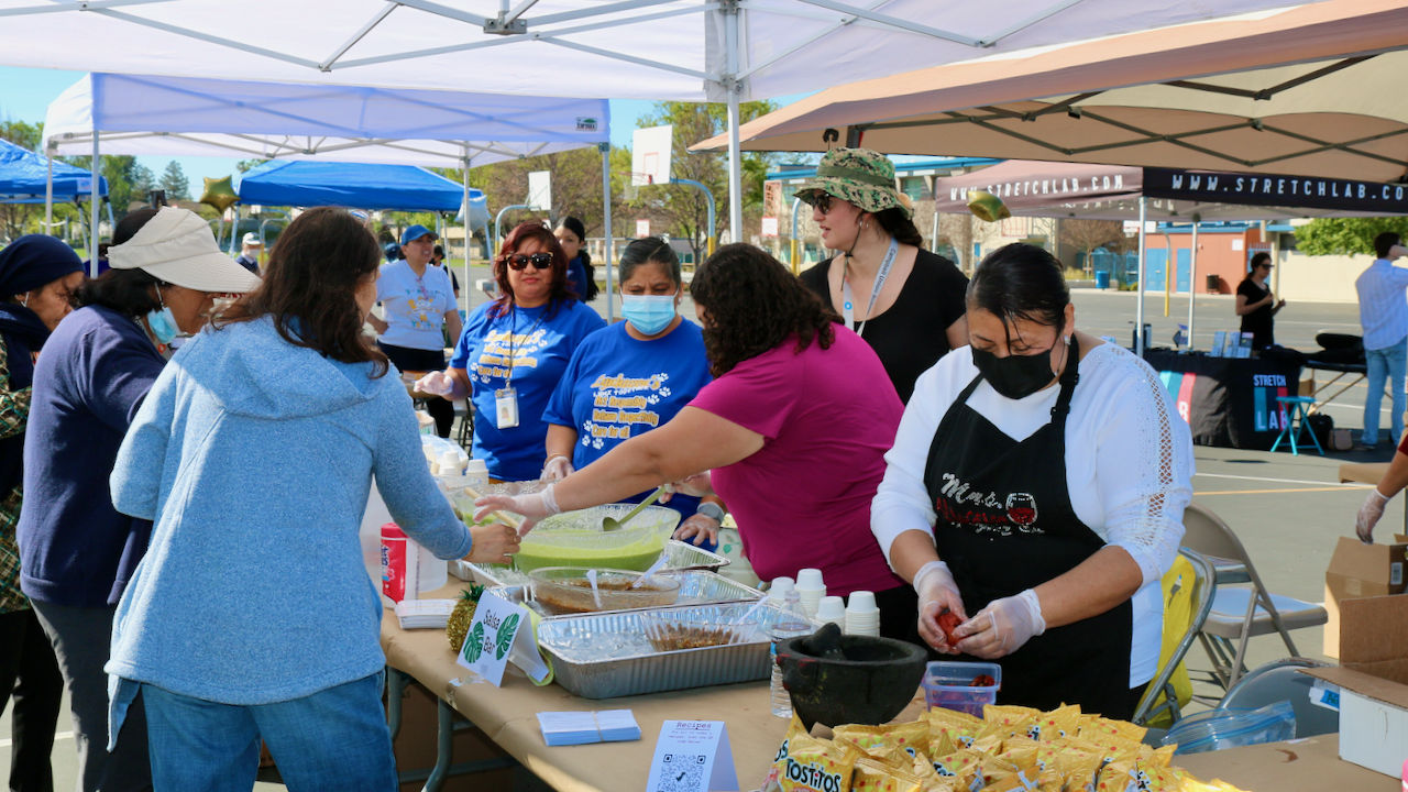 ladies serving fresh food at the wellness fair